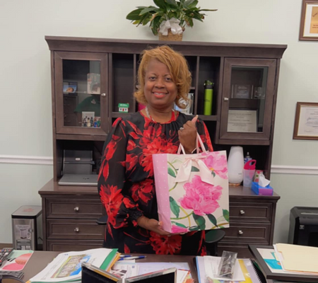 Happy Bosses Day Clamentine Elmore in her office with gift bag