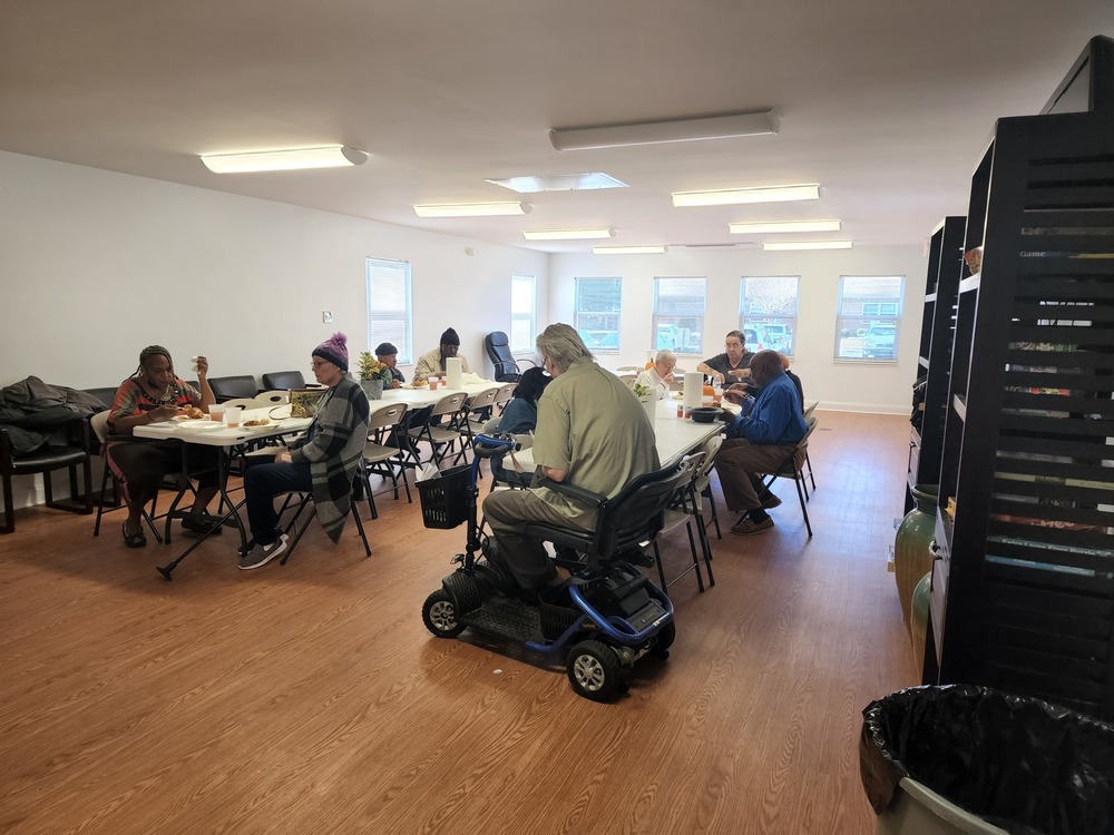 Pelican House residents eating around table at thanksgiving feast