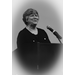 grayscale vignette of woman speaking at microphone