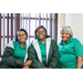 three women in green shirts posing for picture
