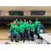 Florence Housing staff in green company tshirts standing in bowling alley posing as a group